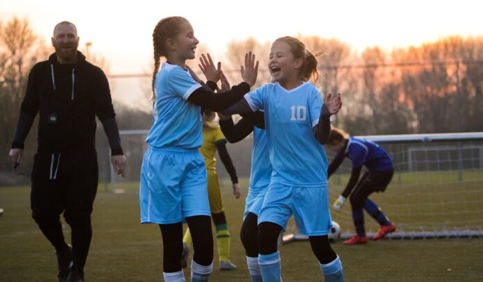 Girls celebrating a goal during a football match